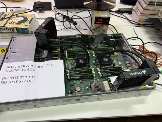 Server with watercooling that is powered from a programmable psu. A sheet of paper on top "Boat server project is taking place, do not touch, do not stare".