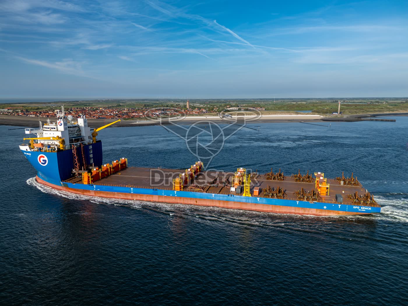 Zwaarliftschip GPO Grace passeert de zeedijk en het kustdorp Westkapelle