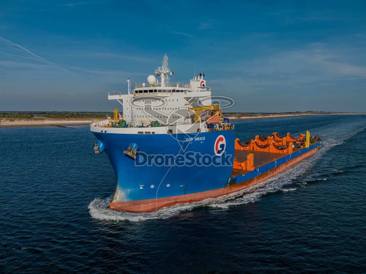 Vooraanzicht van zwaarliftschip GPO Grace varende voor de kustlijn van Westkapelle
