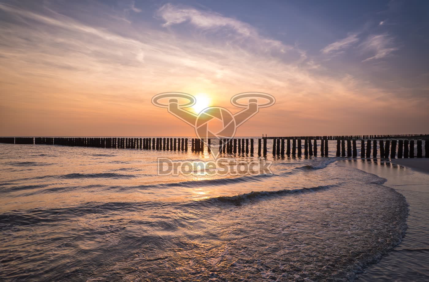 Zonsondergang boven de Noordzee met golfbreker bij Westkapelle