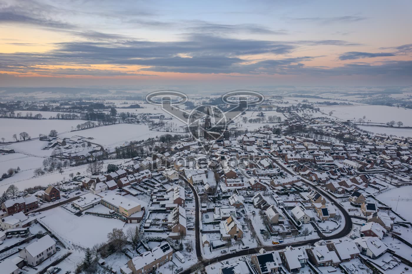 Besneeuwd Limburgs heuvellandschap en dorp Vijlen bij zonsondergang