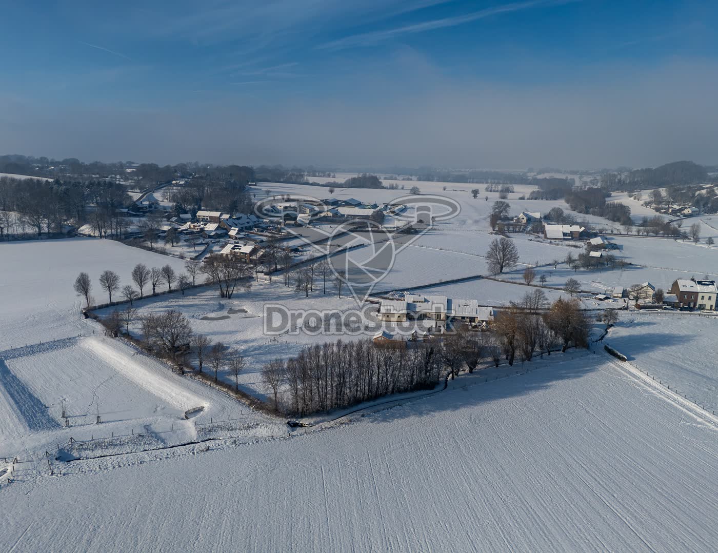 Besneeuwde boerderij en kavel in het Limburgse heuvellandschap
