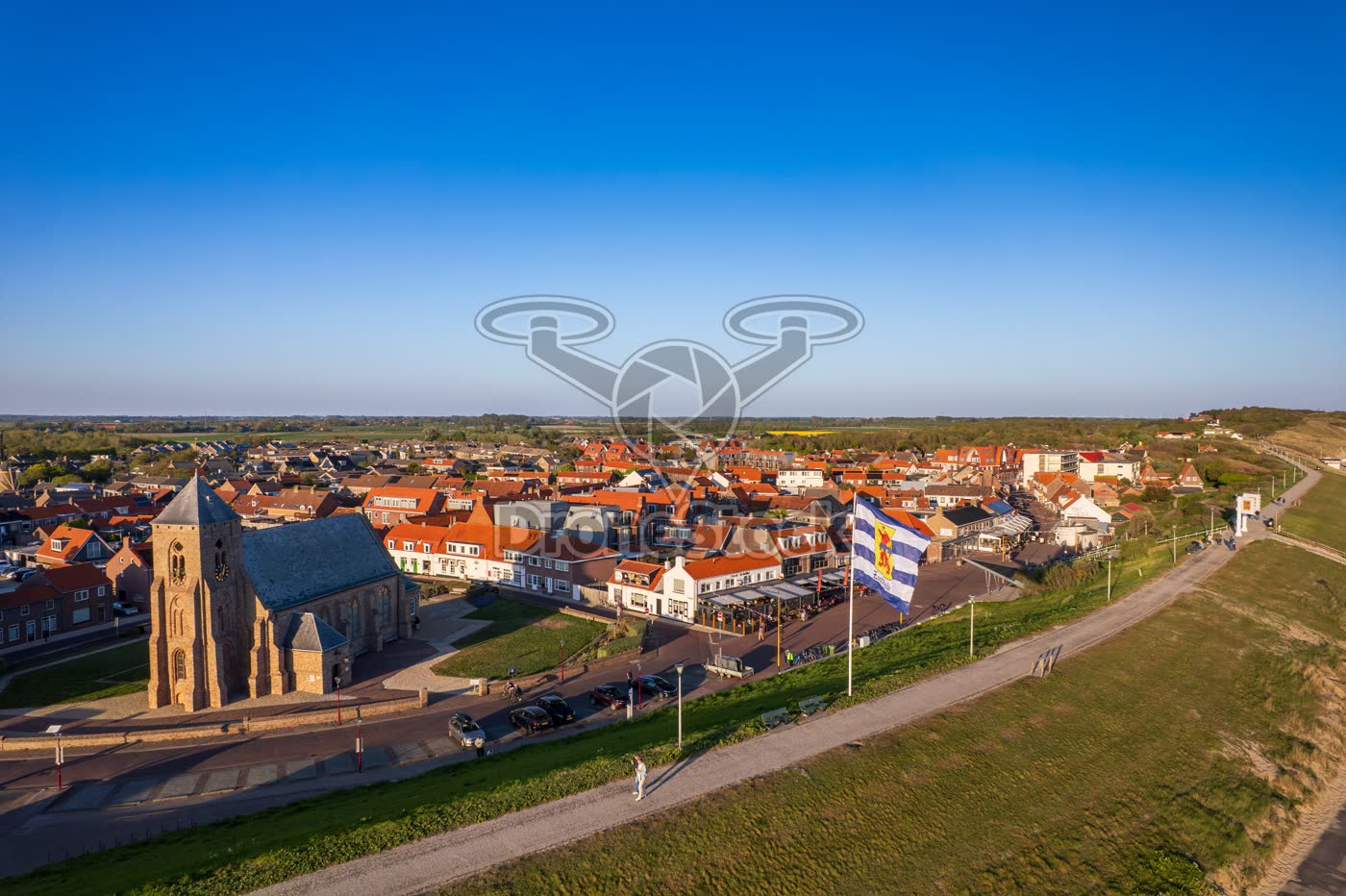 Dorpskern van Zoutelande met Catharinakerk en Zeeuwse vlag op de dijk