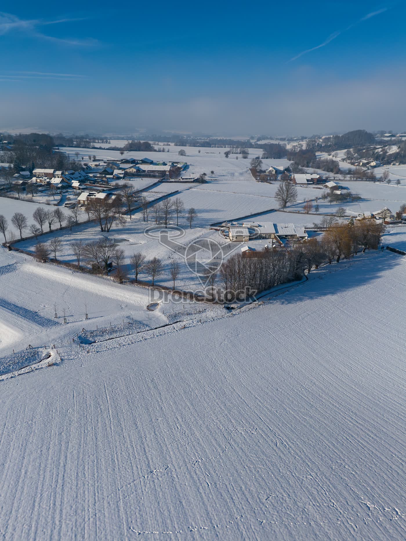 Sneeuw bedekte akkers en boerderij in het buitengebied van Vijlen