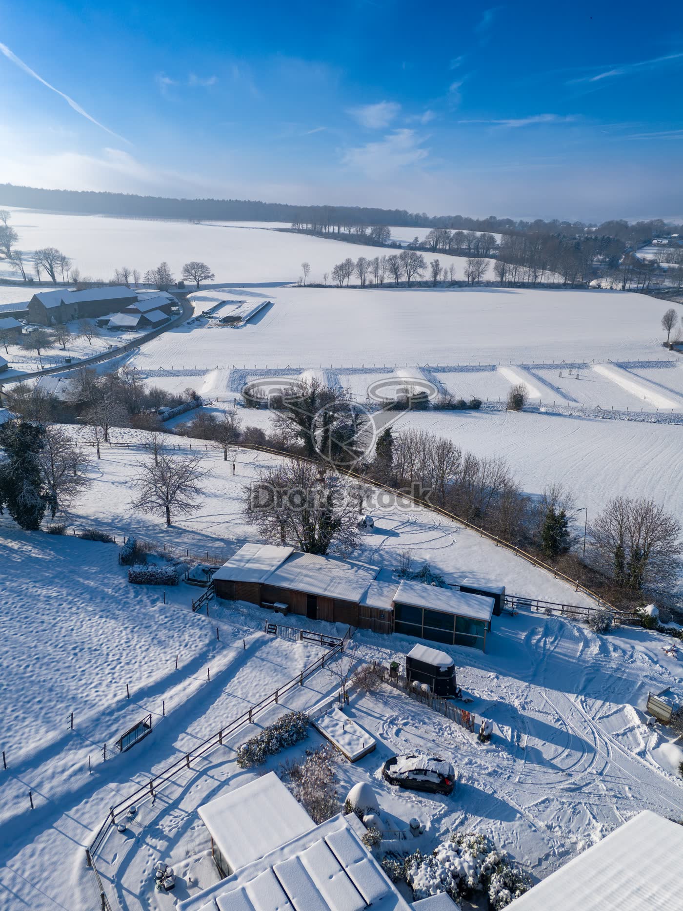 Besneeuwde paardenstallen en weides in het buitengebied van Vijlen