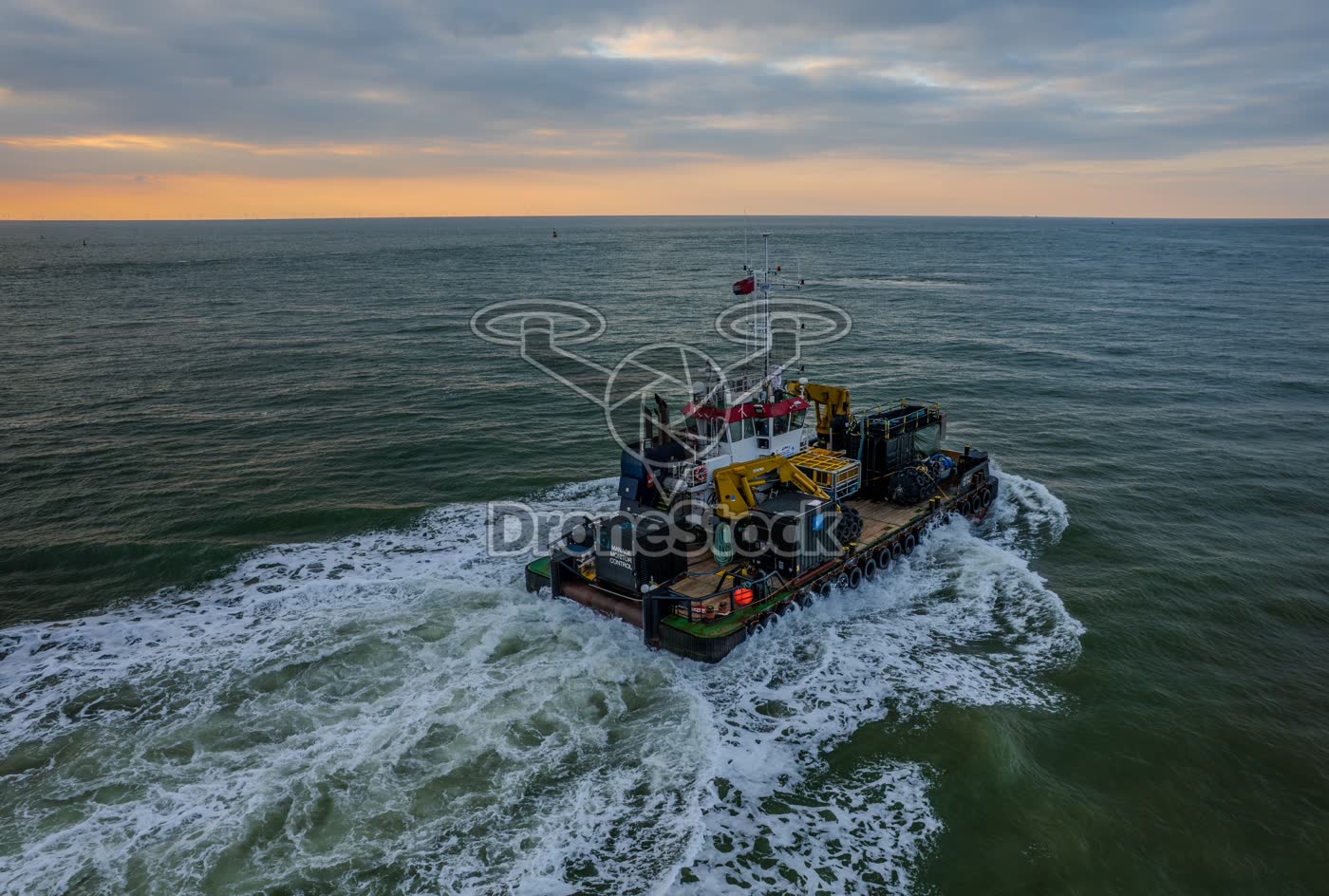 Aanzicht van achterkant van een offshore werkboot in volle vaart bij Westkapelle