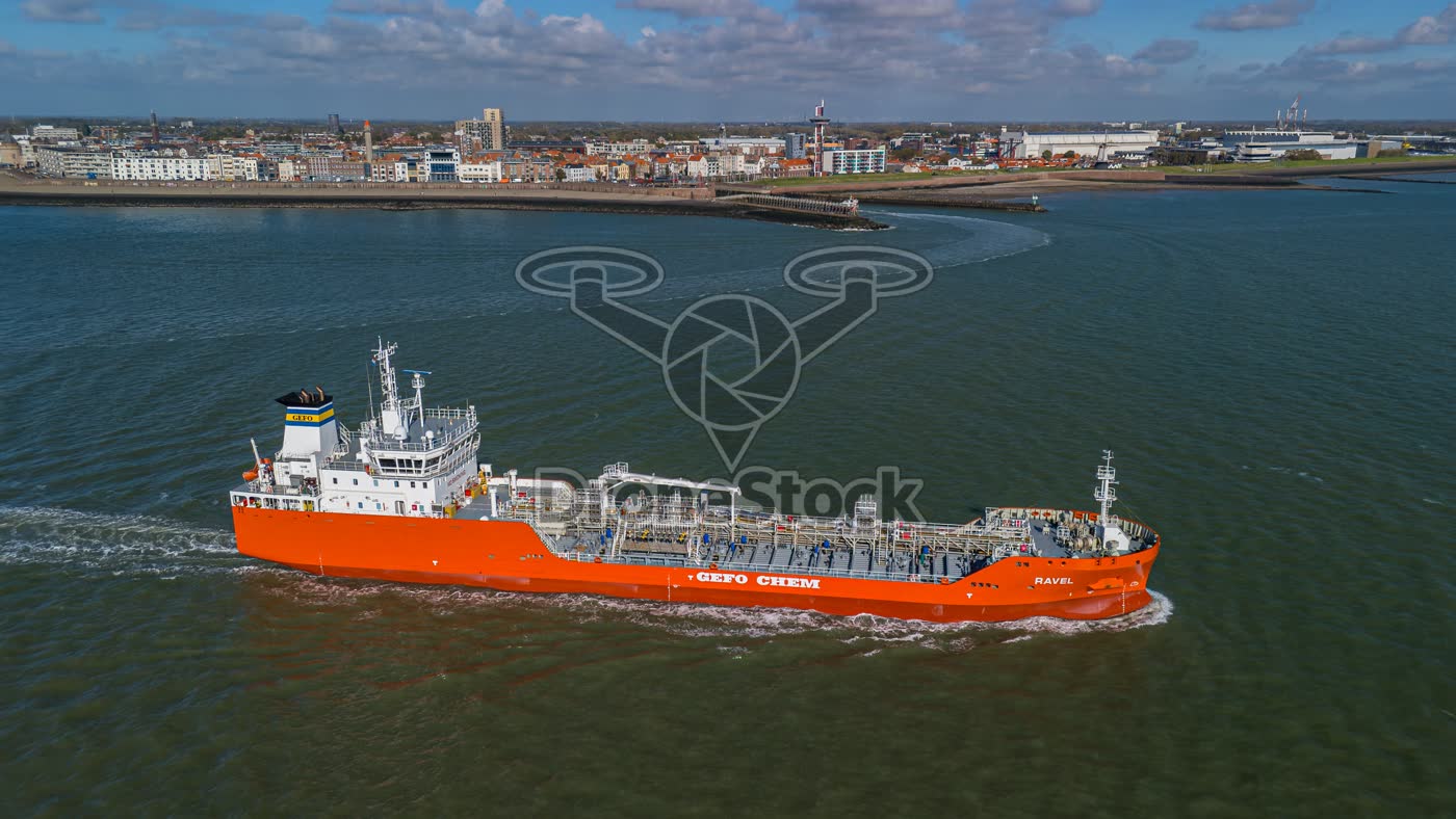 Oranje chemicaliëntanker Ravel vaart langs de skyline van Vlissingen