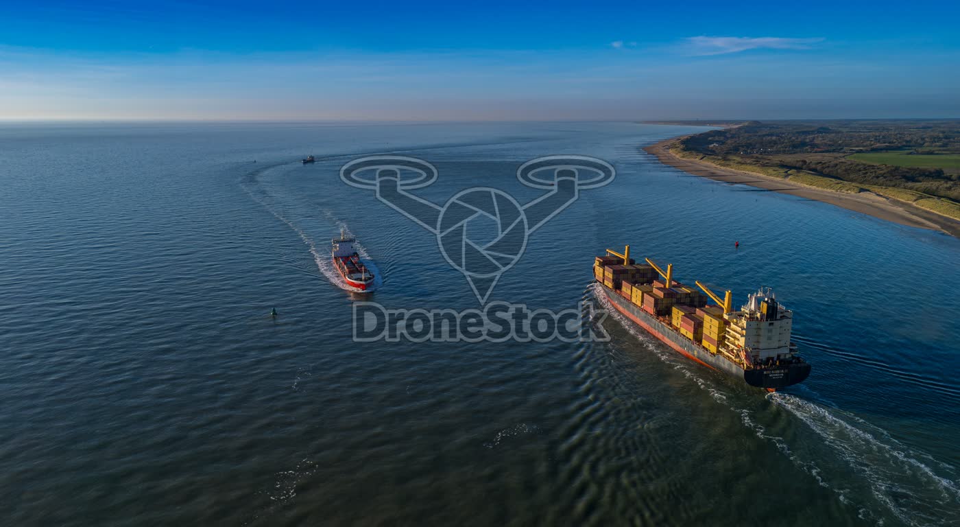 Hoge luchtfoto van passerende vrachtschepen langs het Zeeuwse strand van Vlissingen