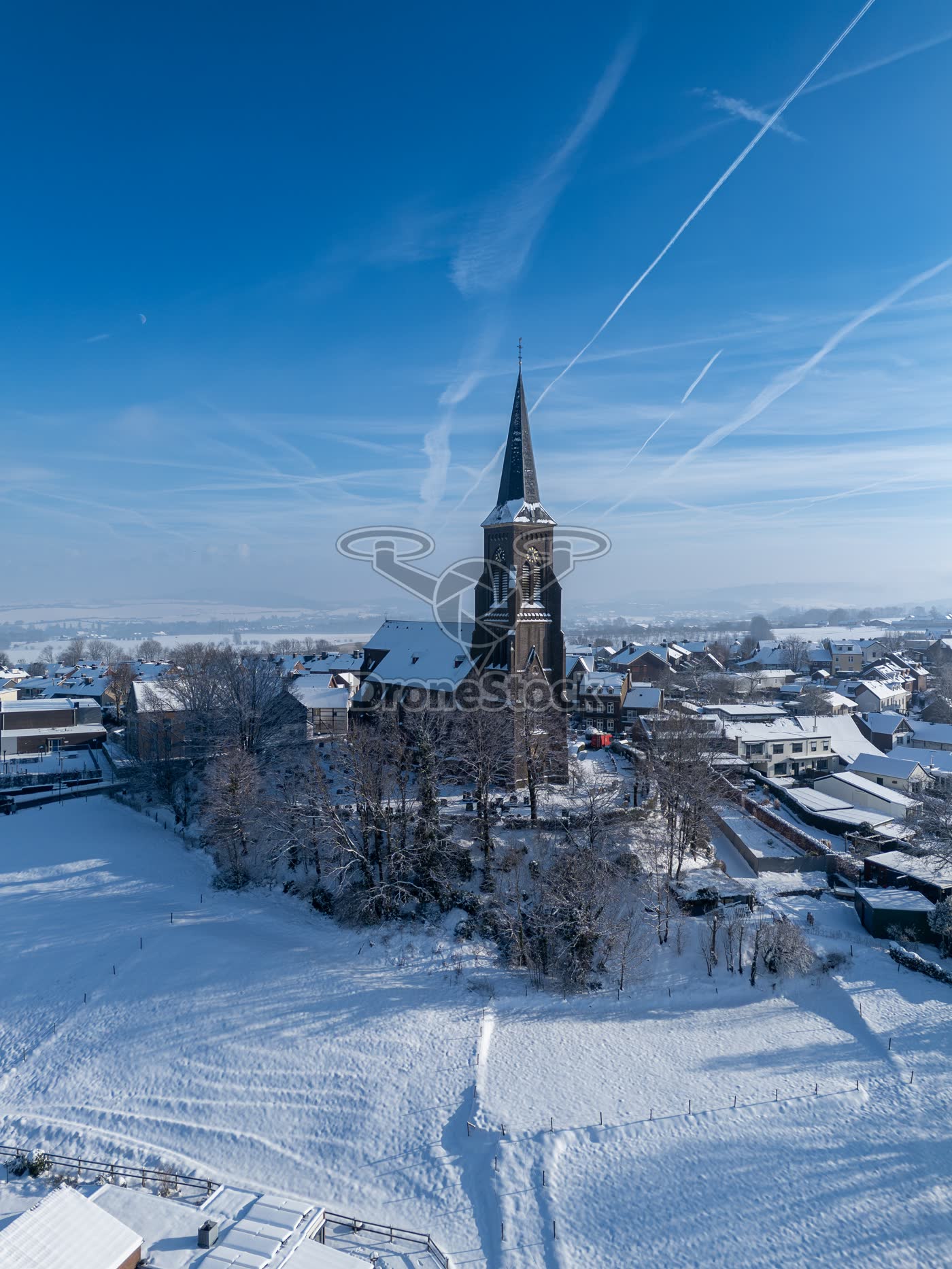 Luchtweergave van de Sint-Martinuskerk en besneeuwde landschap in Vijlen