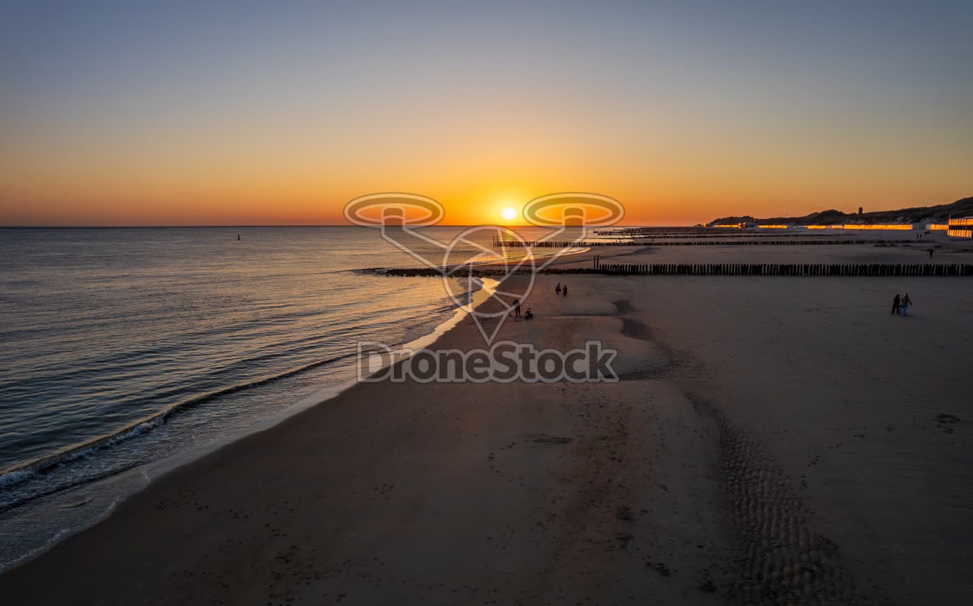 Zonsondergang boven zee en strand met strandvissers in Zoutelande