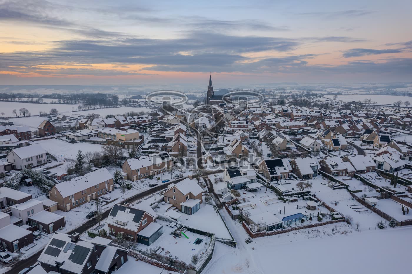 Luchtfoto van het besneeuwd bergdorpje Vijlen in avondlicht