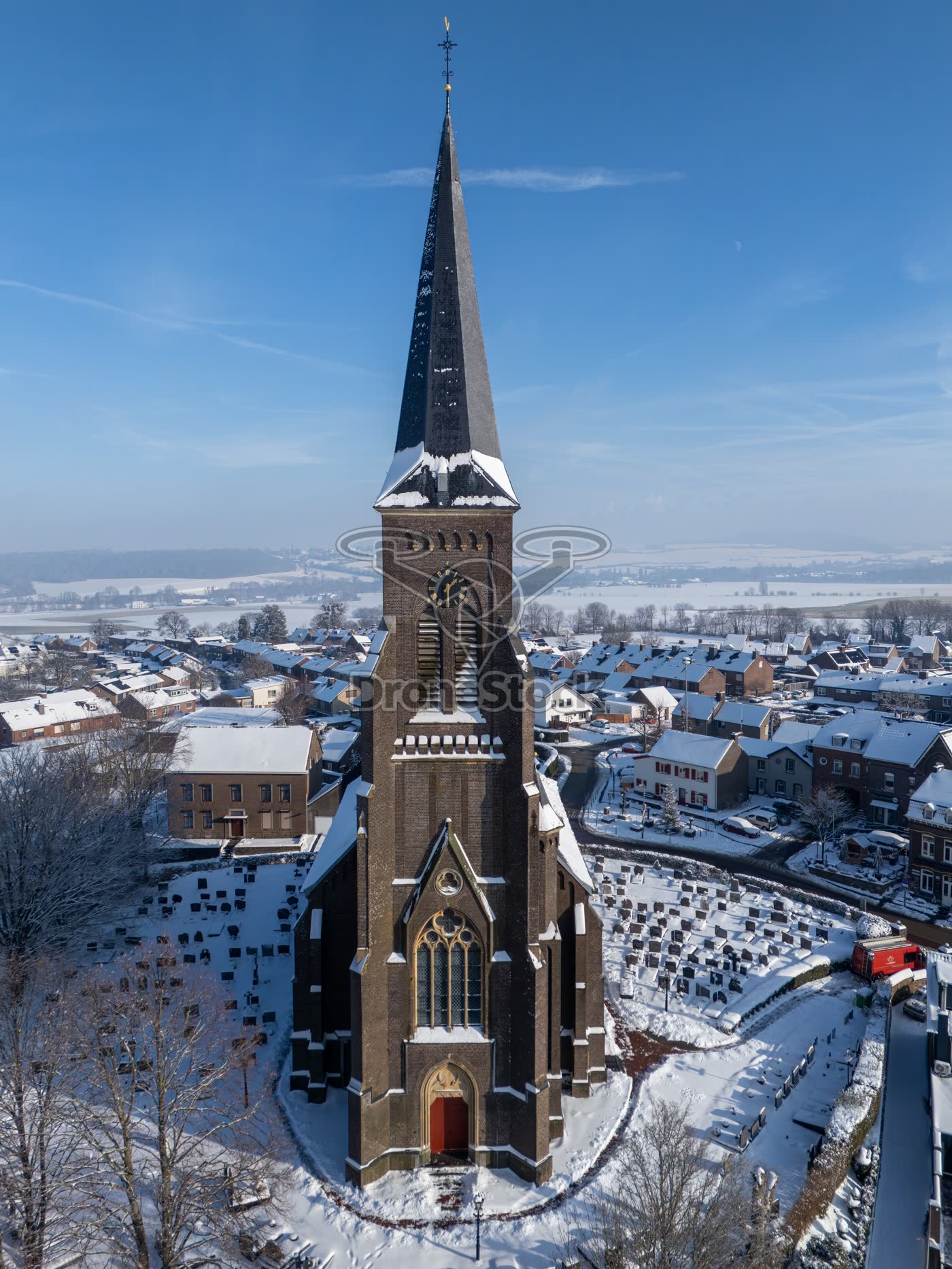 Hoge verticale drone-opname van de Sint-Martinuskerk in een besneeuwd Vijlen