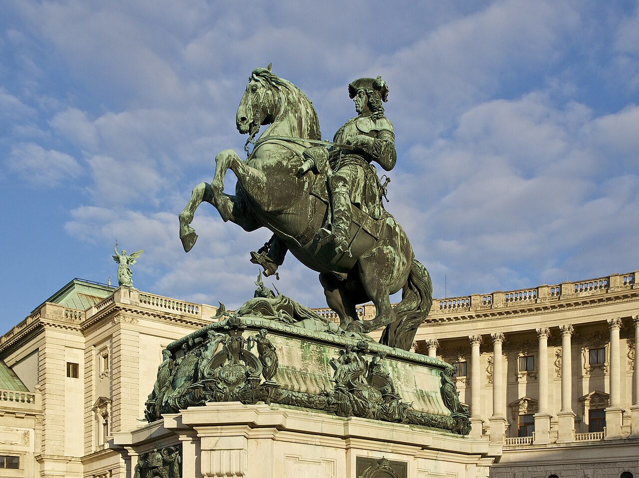 Bronze equestrian statue of Prince Eugene of Savoy on Heldenplatz in Vienna, with the curved stone facade and arched windows of the Neue Burg behind