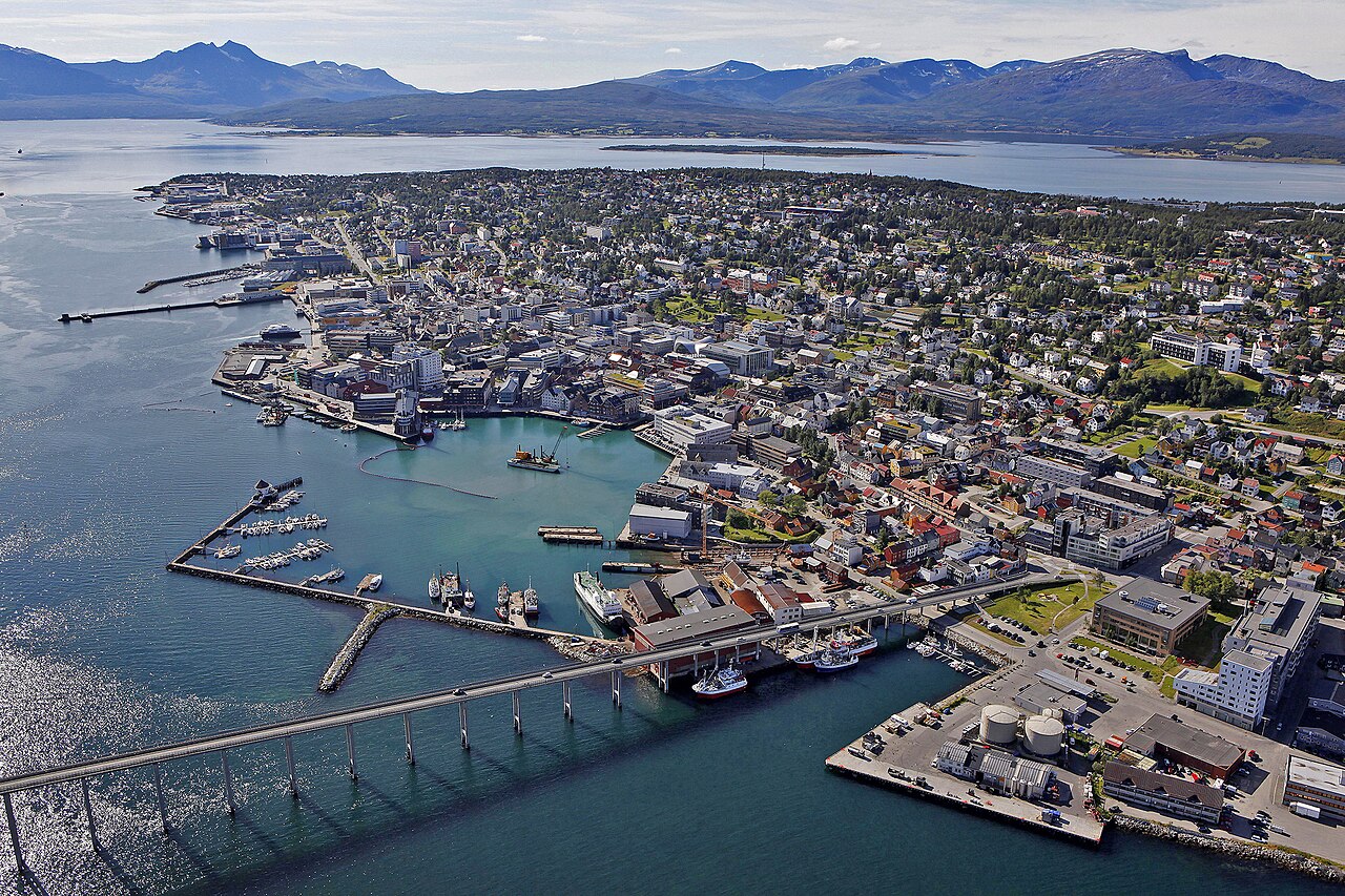 Tromsø surrounded by fjords and the bridge across the fjord — the city lies right in the center of the aurora oval. Just a few kilometers outside town, you'll find dark skies free of light pollution, which is its geographical advantage as an aurora base.