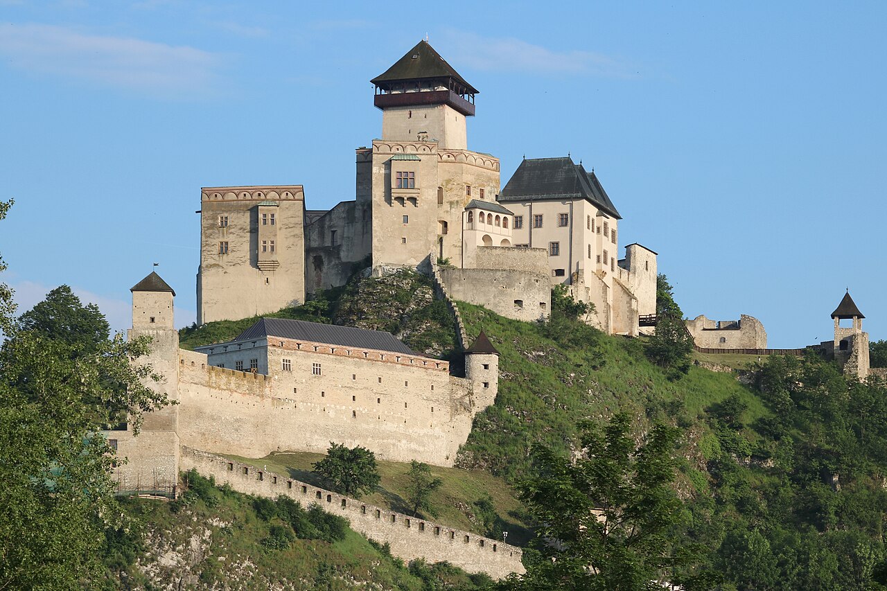 Trenčín Castle in Slovakia: a white-walled medieval castle complex on a tree-covered rocky hill
