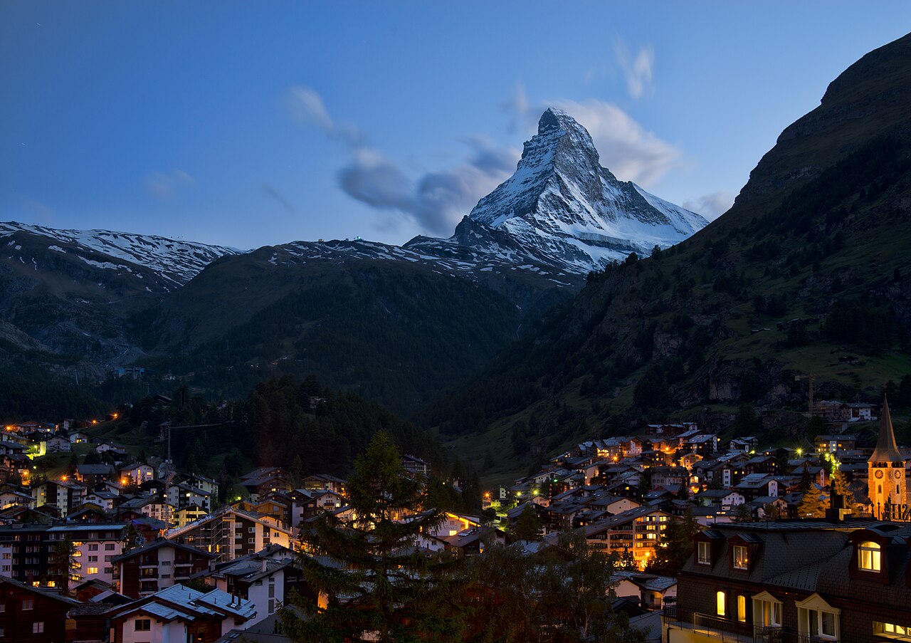 Twilight view of Zermatt village lights and the distant Matterhorn