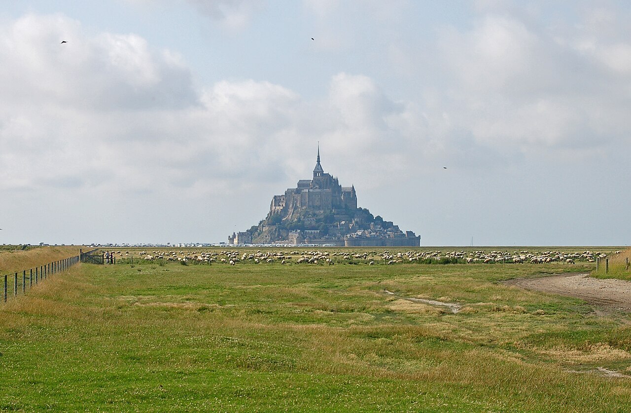 A hotel room with a window facing the Mont-Saint-Michel abbey and the open bay, showing the mudflats at low tide. This illustrates the actual view from accommodations on the island, allowing users to assess the scenic or abbey value of different room types.