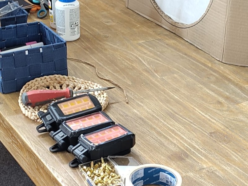 Tafel met alle benodigdheden en ca. vijf minikasten om te oefenen voor elk groepje