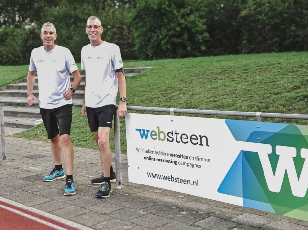 Dennis en Roy bij bij het reclamebord van Websteen tijdens de Wolfskamerloop 2022