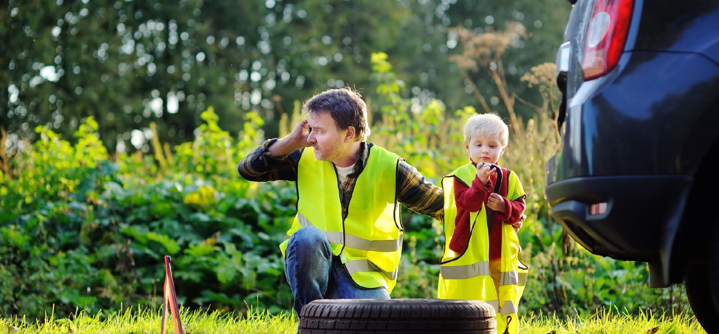 2 kinderen bij een auto met een lekke band