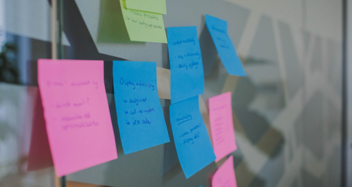 Post-its met tekst op een raam geplakt.
