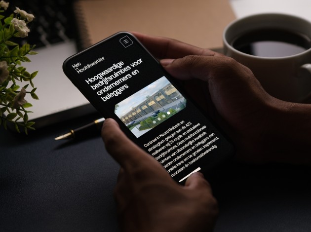Iphone met de website van Het Hoofdkwartier in beeld