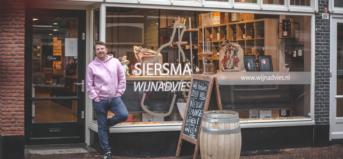 Rutger Siersma voor de etalage van zijn wijnwinkel in Baarn