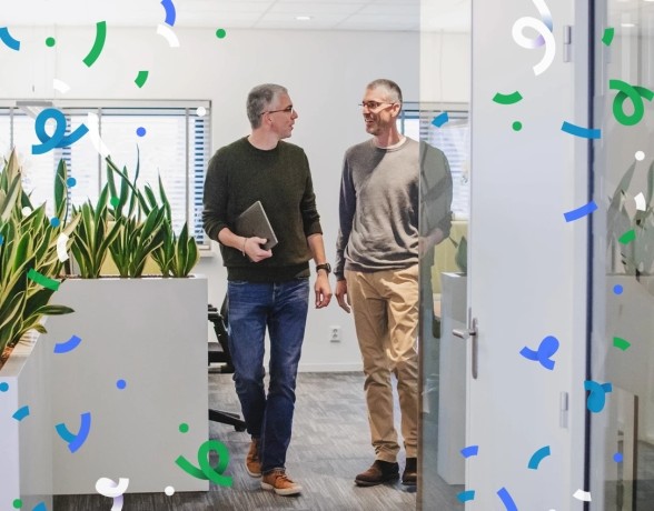 Dennis en Roy lopen door kantoor met confetti over de foto