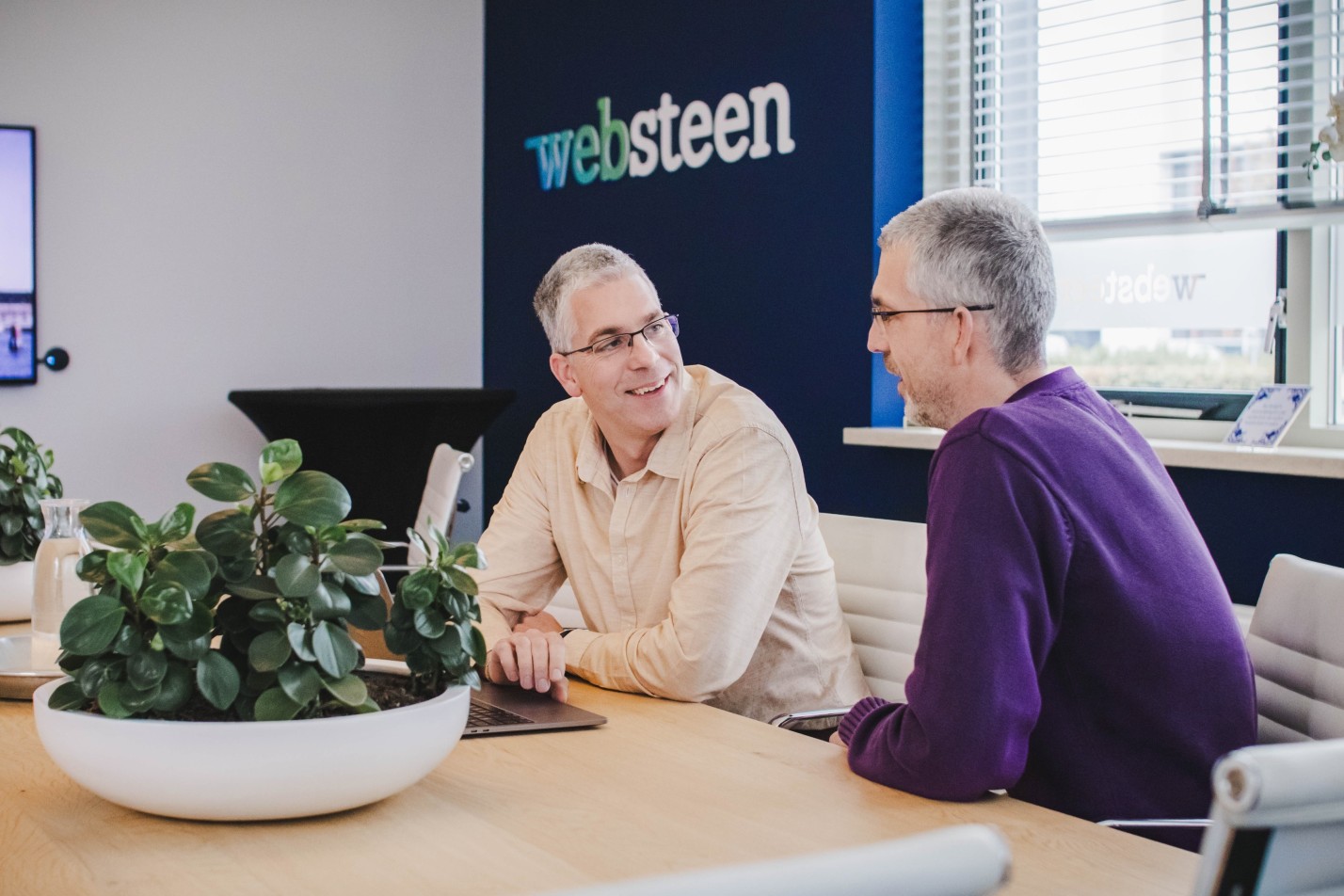 Roy en Dennis aan tafel in een spreekruimte