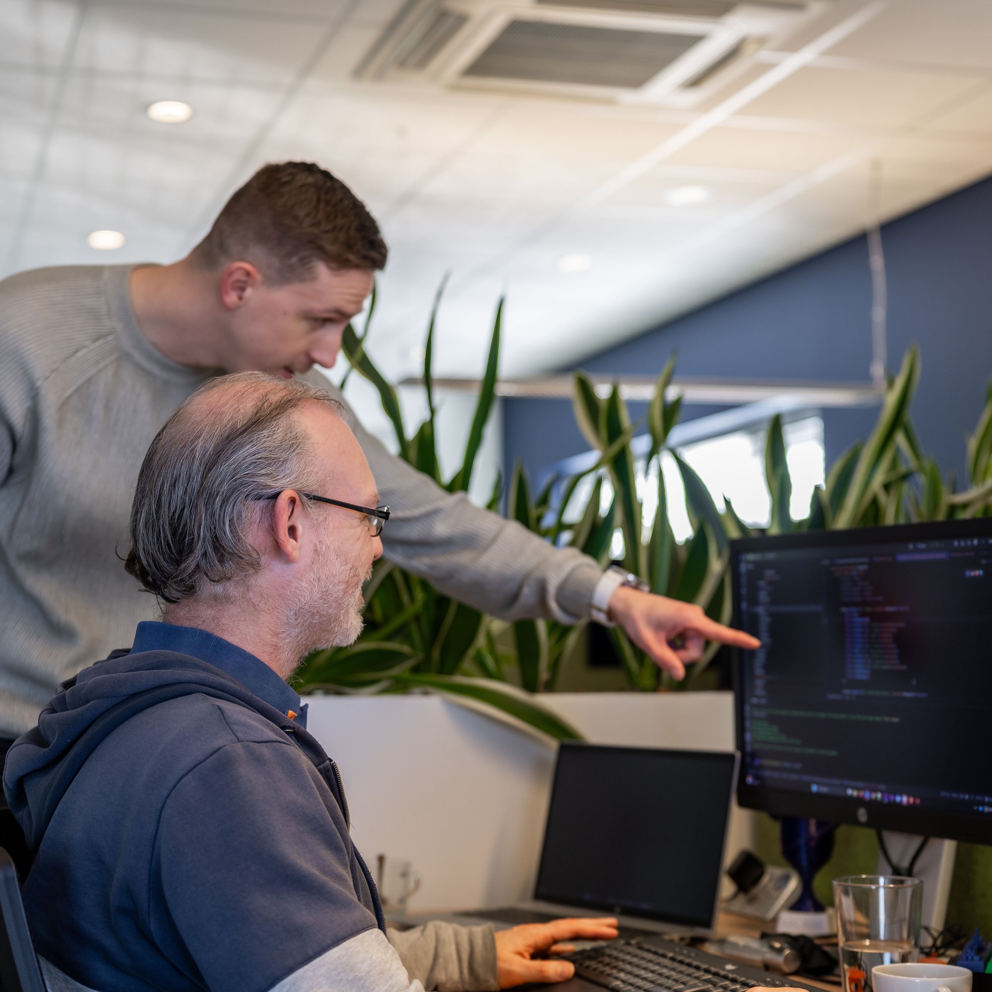 Eelco aan het werkt terwijl Chris wat vraagt