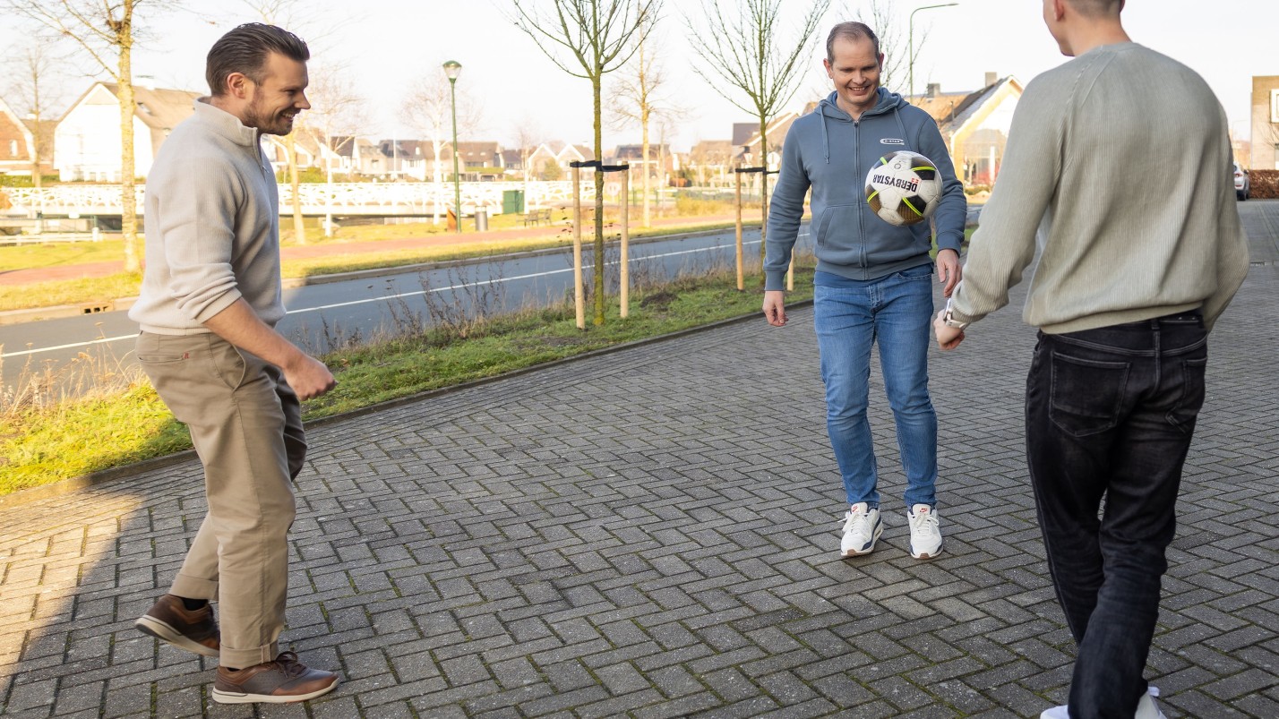 Wesley voetbalt met collega's op de parkeerplaats