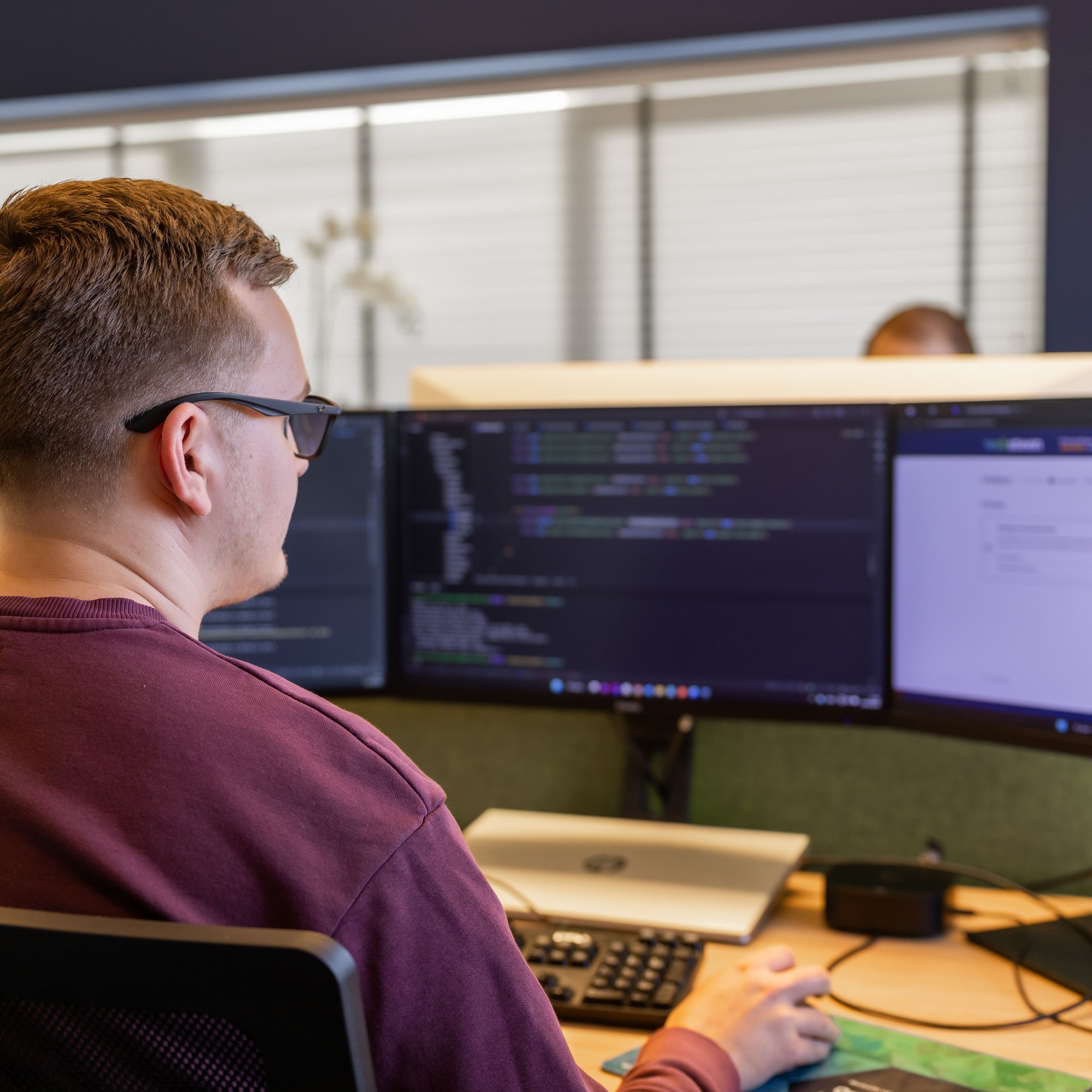 Programmerende Djim achter zijn bureau