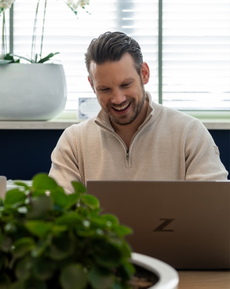 Wesley de vormgever achter een laptop