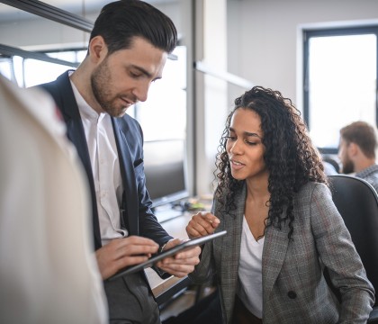 Twee medewerkers kijken samen naar tablet