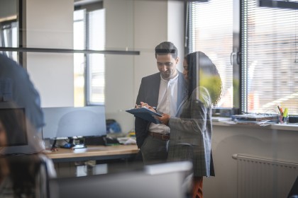 Twee medewerkers kijken samen naar tablet
