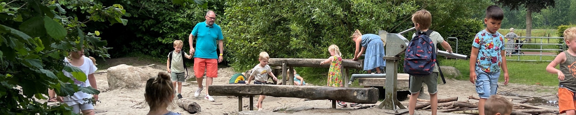 Kinderen spelend in de natuurspeelplaats.