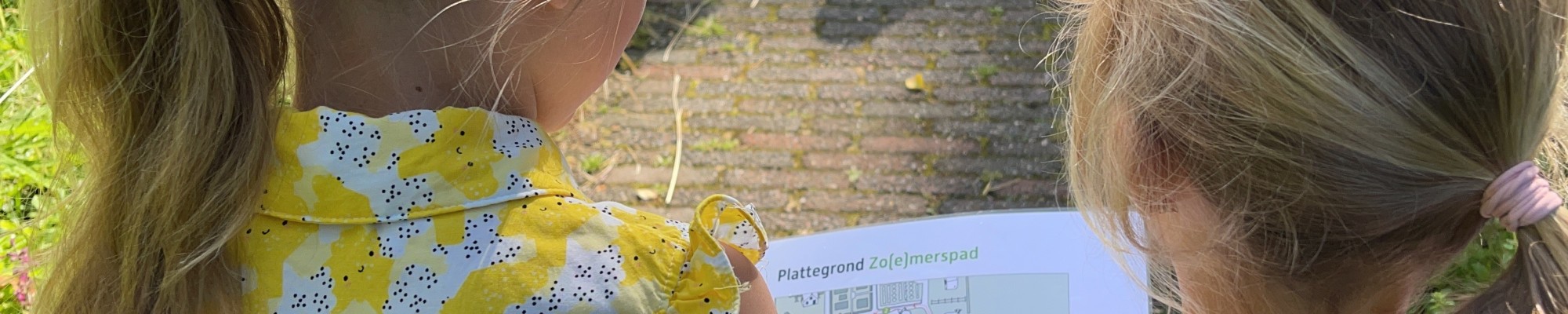 Kinderen die kijken naar een plattegrond van het Goden en Godinnenpad.