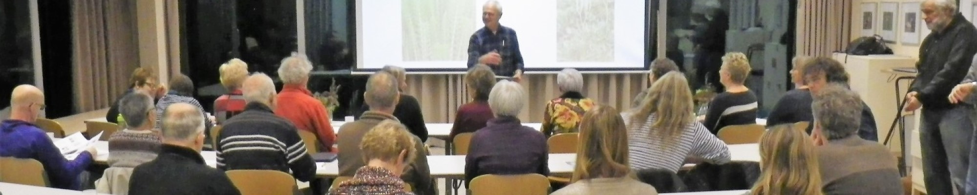 Volwassenen aandachtig luisterend bij een lezing.