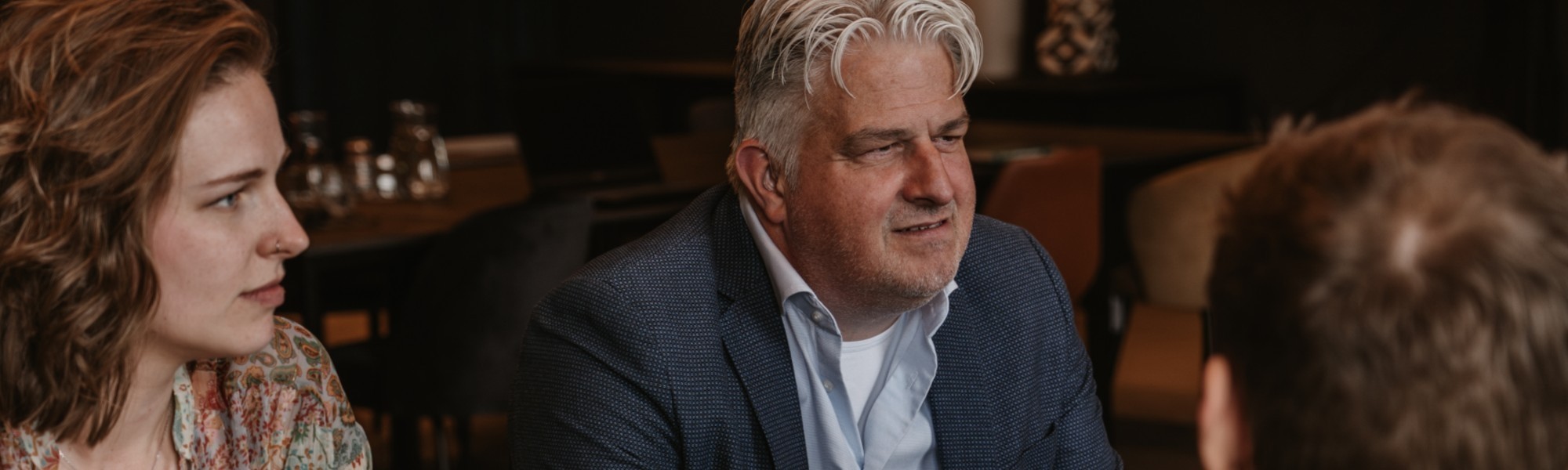 Ron van den Wijngaard biedt financiële ondersteuning aan eenmanszaken. Foto toont Ron in overleg met een klant, terwijl ze samen werken aan zakelijke oplossingen op een laptop, in een persoonlijke setting.