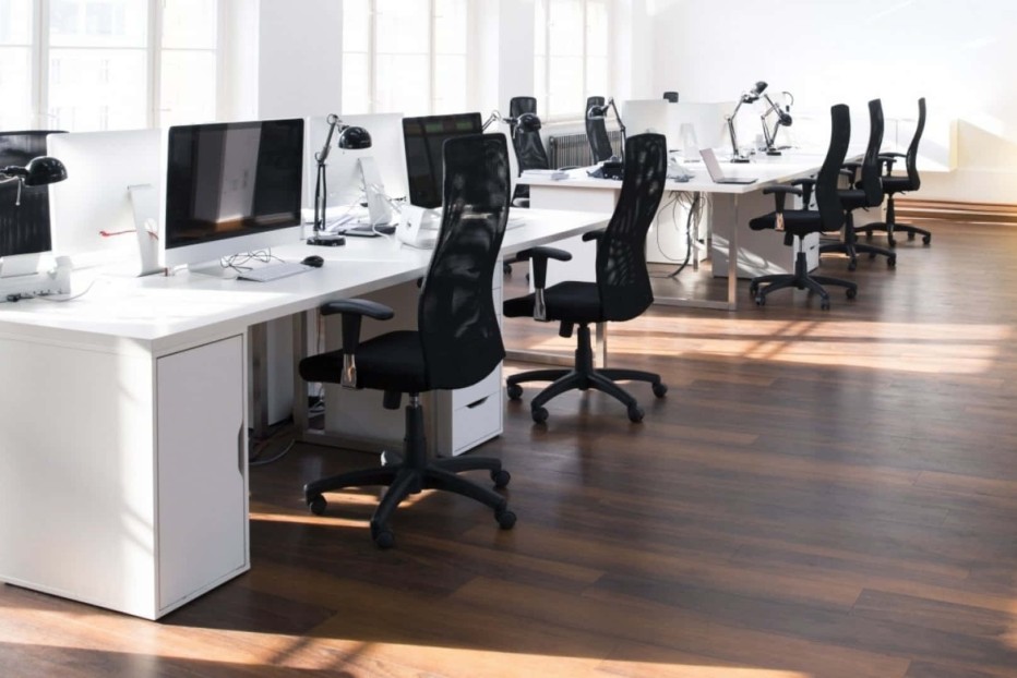 Bureaustoelen aangeschoven bij de werkstations.