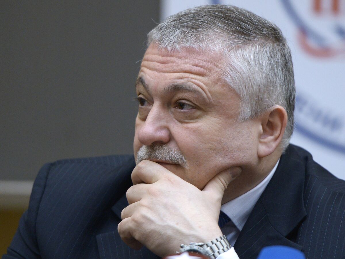 Космонавт Федор Юрчихин в окружении детей в школьном классе, демонстрирует что-то на кроссовке.