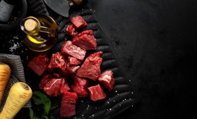 Женщина с грустным лицом смотрит на аппетитный кусок мяса, символизируя отказ от него в Великий пост