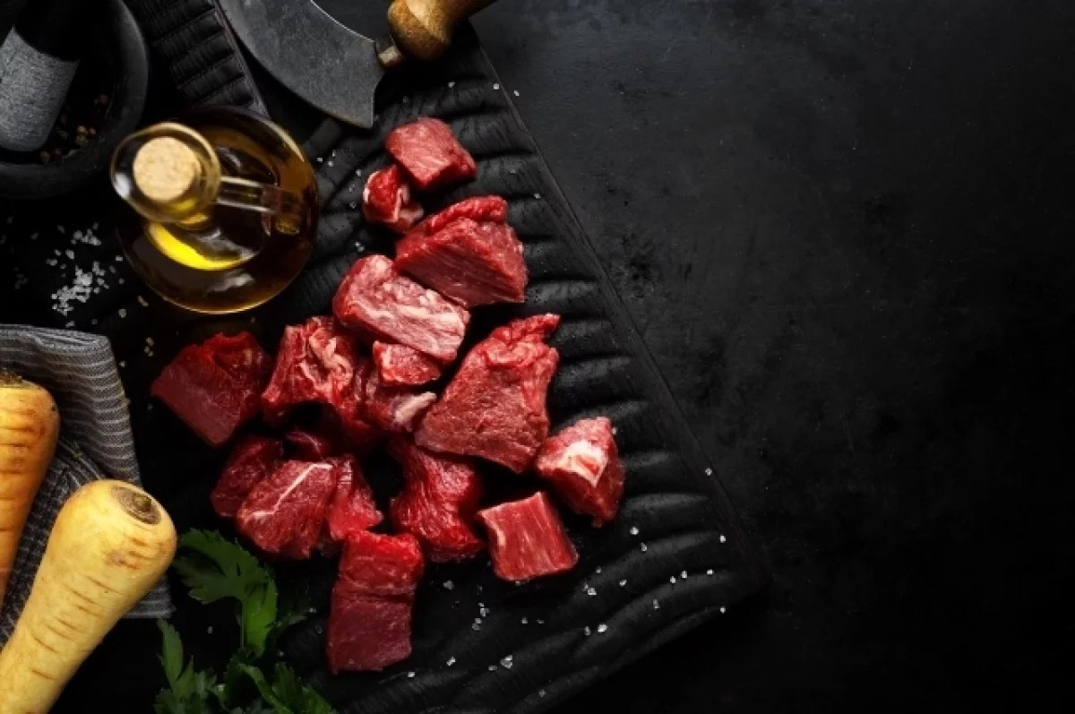 Женщина с грустным лицом смотрит на аппетитный кусок мяса, символизируя отказ от него в Великий пост