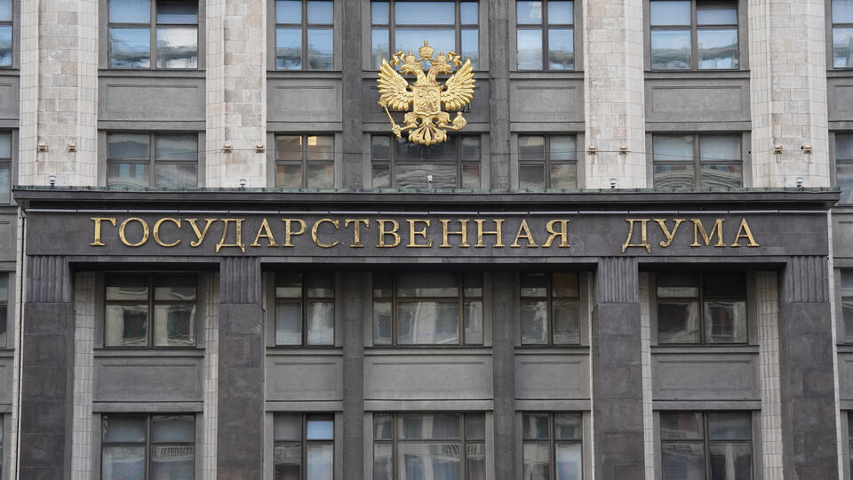Изображение, символизирующее совершеннолетие и финансовую ответственность: возможно, рука, держащая монету или счет, на фоне здания Государственной Думы или стилизованного лабиринта.