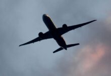 Группа российских туристов с чемоданами на фоне аэропорта, символизирующая возвращение домой после отдыха на Кубе