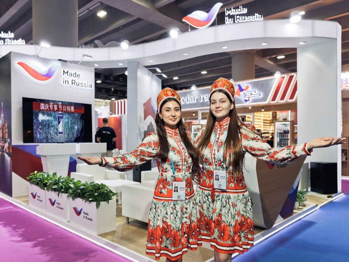 Группа российских предпринимателей на фоне оживленной торговой выставки в Кантоне, Китай