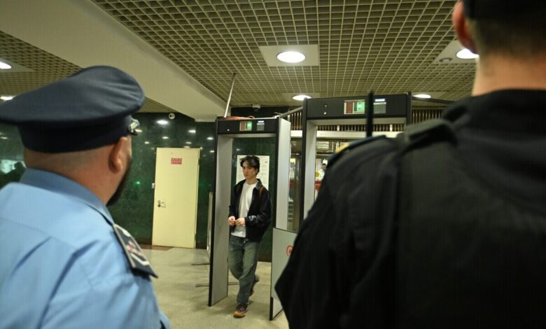 Мужчина в метро Санкт-Петербурга, сидящий на полу, возможно, под воздействием алкоголя, с книгой рядом.