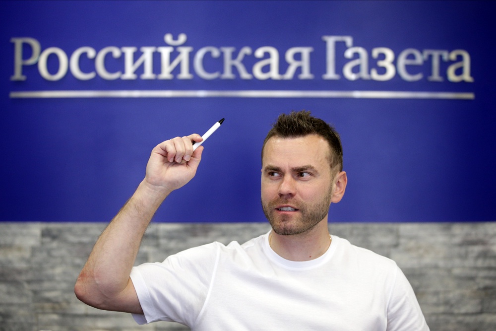 Книжная полка с книгами, посвященными Игорю Акинфееву, на фоне изображений Роналду и Месси.