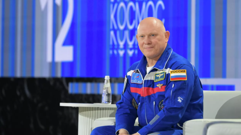 Астронавт с татуировкой на руке, смотрящий на люк космического корабля