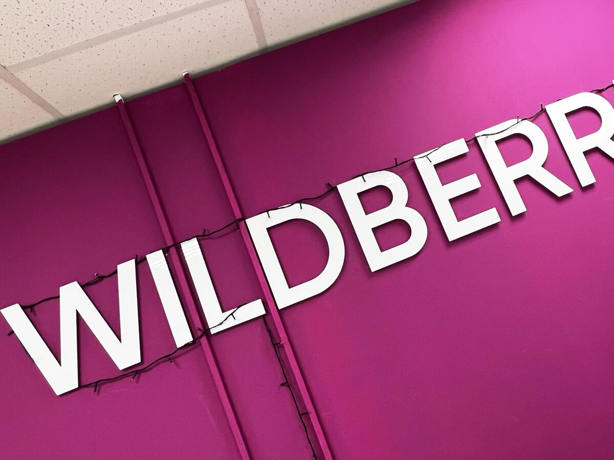 Изображение с намеком на фиолетовый цвет Wildberries и атрибуты такси, возможно, с вопросом о выборе между шашечками и ягодами.